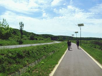 People walking on road against sky