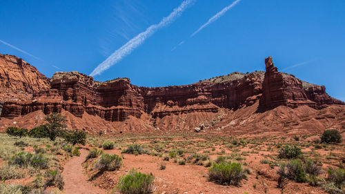 Rock formations on landscape against blue sky