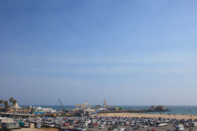 Cars in parking lot at santa monica pier against blue sky