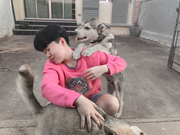 Girl with dog sitting outdoors
