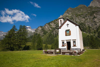 Built structure by trees on mountain against sky