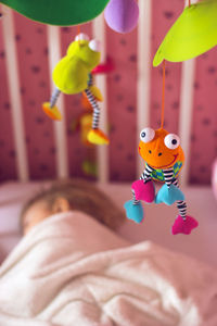 Close-up of stuffed toy hanging on bed at home