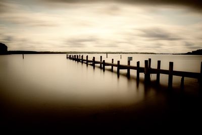 Wooden pier on sea against sky during sunset