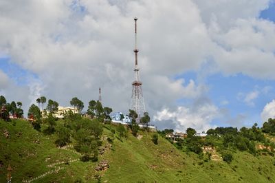 Panoramic view of communications tower and trees against sky