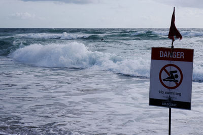 Danger sign board at sea shore