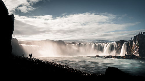 Scenic view of waterfall against sky