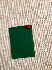 Close-up high angle view of blank green paper on textile