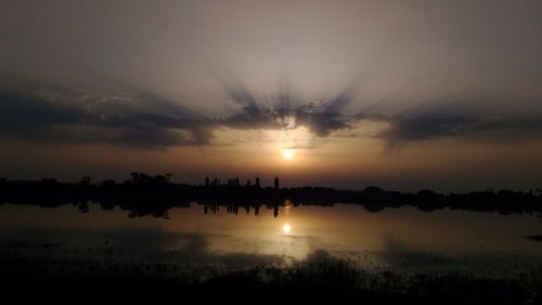 Scenic view of lake against sky during sunset