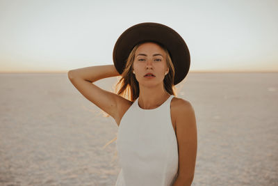 Portrait of young woman standing at beach