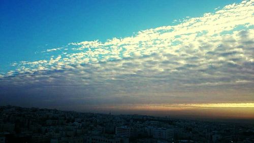 Cityscape against cloudy sky