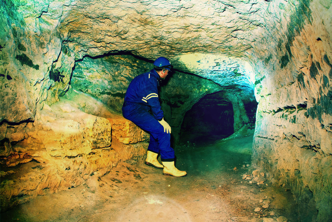 REAR VIEW OF MAN STANDING ON ROCK