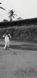 Rear view of woman on field against sky