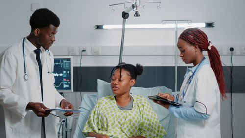 Doctors examining patient at hospital