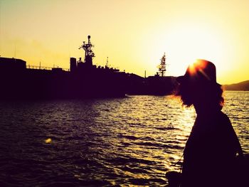 Silhouette of people in river at sunset