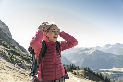 Austria, tyrol, happy woman on a hiking trip in the mountains enjoying the view
