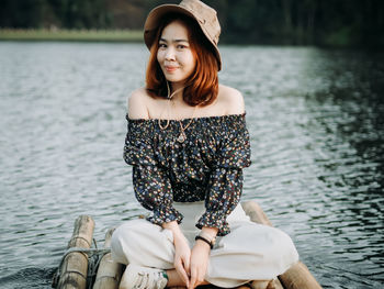 Young woman sitting by lake