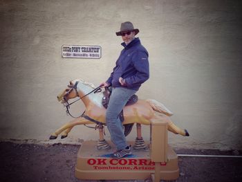 Full length of man sitting on wall