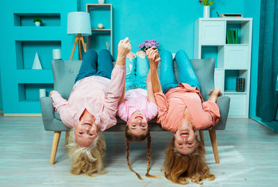 Portrait of smiling family lying on sofa at home