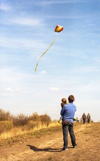 Father and son against sky