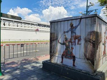 Statue on street against building in city