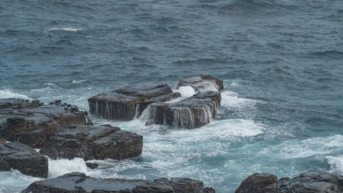 Scenic view of rock in the sea against sky