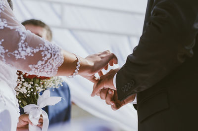 Midsection of bride and groom during wedding