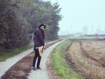 Young man walking on country road