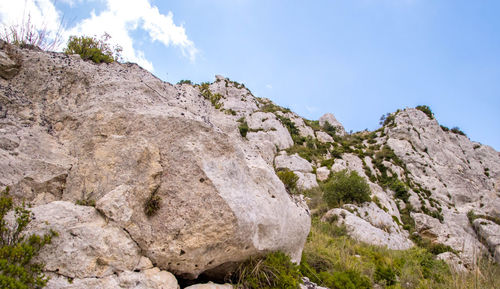 Low angle view of rocky mountain against sky