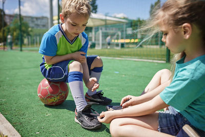 Friends sitting on soccer field