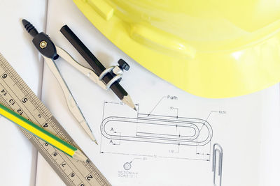 Close-up of blueprints with instruments and hardhat