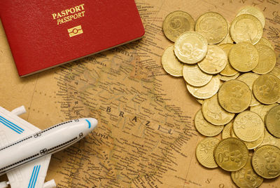 Directly above shot of coins with passport on map