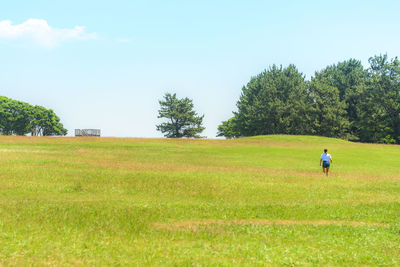 Man on golf course against clear sky