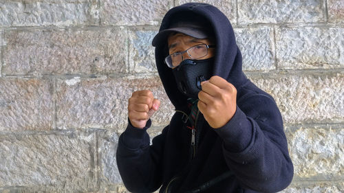 Portrait of man standing against wall