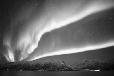 Scenic view of snowcapped mountain against sky at night