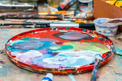 Bright colors in the artist's palette and a brush in an art workshop