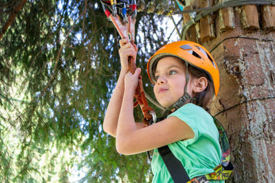 Adventure climbing high wire park - people on course in mountain helmet and safety equipment