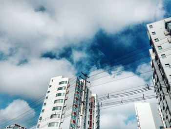 Low angle view of amusement park against cloudy sky