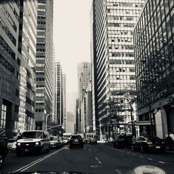 Traffic on road amidst buildings in city