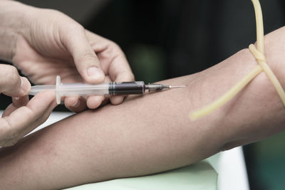 Cropped image of doctor taking blood sample of patient