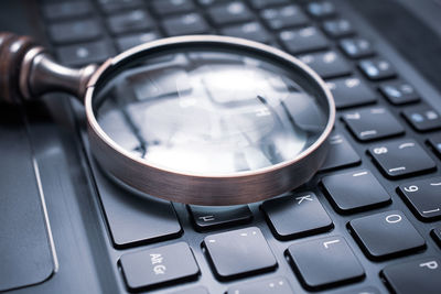 Close-up of magnifying glass on laptop