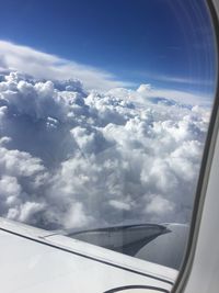 Close-up of airplane wing against cloudy sky