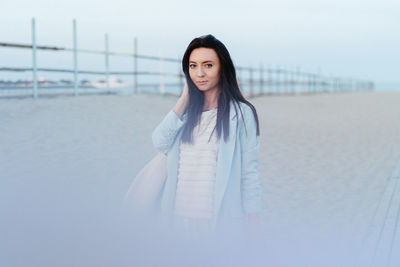 Portrait of a beautiful model walking on the beach at sunset