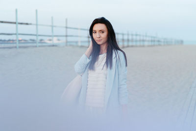 Portrait of beautiful woman standing on land against sky