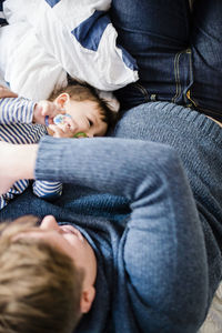 Rear view of father and son lying on bed