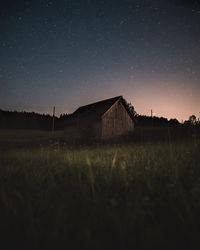 House on field against sky at night