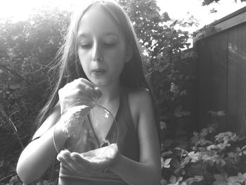 Girl making bubble from soap in back yard