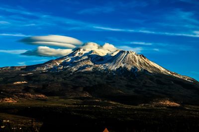 Scenic view of mountains against blue sky