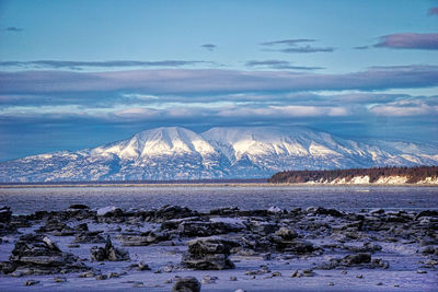 Scenic view of snowcapped mountains by sea against sky