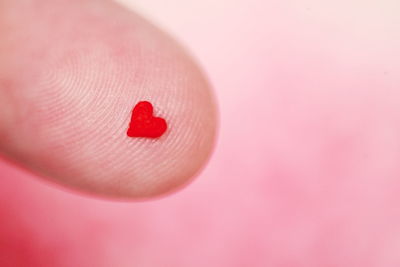 Close up of red love heart on finger tip