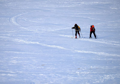 People skiing on snow covered landscape